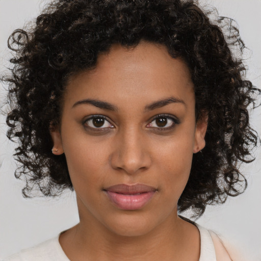 Joyful black young-adult female with medium  brown hair and brown eyes