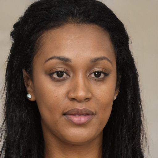Joyful black young-adult female with long  black hair and brown eyes