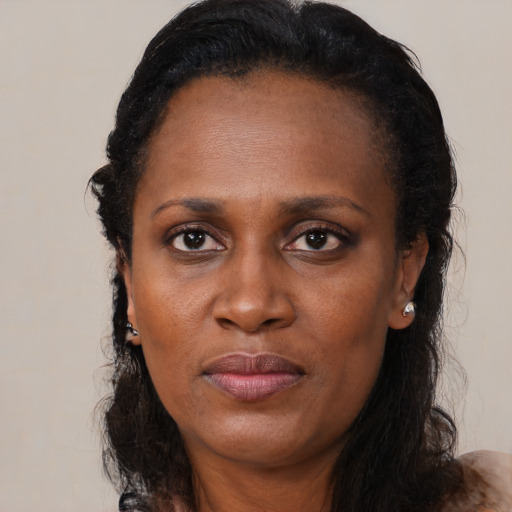Joyful black adult female with long  black hair and brown eyes