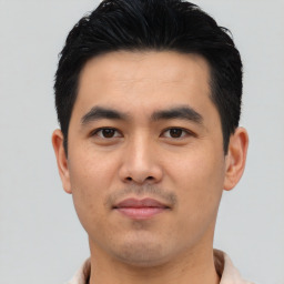 Joyful asian young-adult male with short  black hair and brown eyes