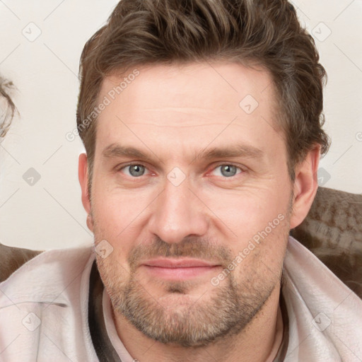 Joyful white adult male with short  brown hair and blue eyes