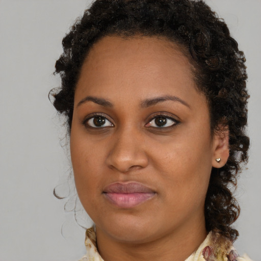 Joyful black young-adult female with medium  brown hair and brown eyes