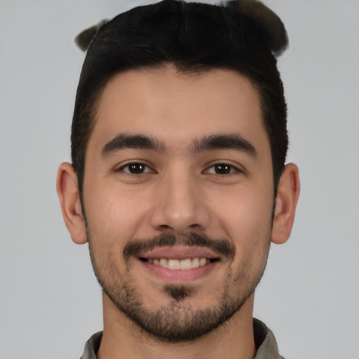 Joyful white young-adult male with short  black hair and brown eyes