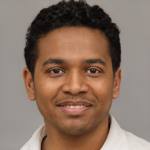 Joyful latino young-adult male with short  brown hair and brown eyes