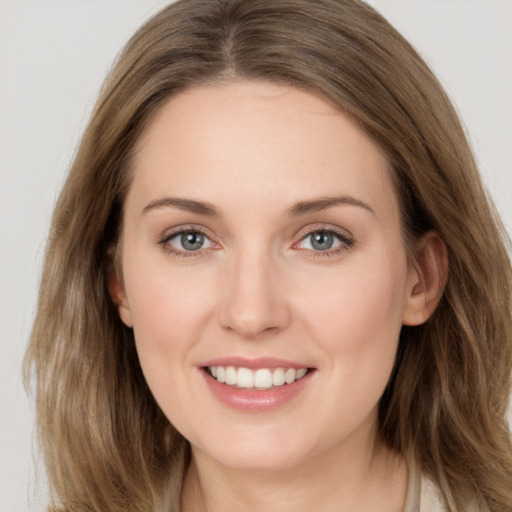 Joyful white young-adult female with long  brown hair and grey eyes