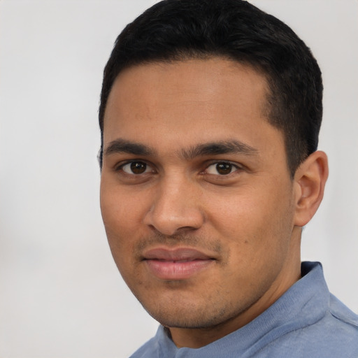 Joyful latino young-adult male with short  black hair and brown eyes