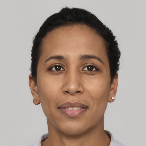 Joyful black young-adult female with short  black hair and brown eyes