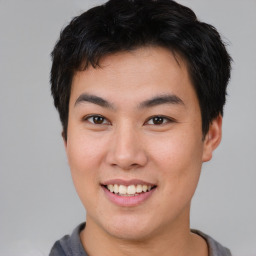 Joyful asian young-adult male with short  brown hair and brown eyes