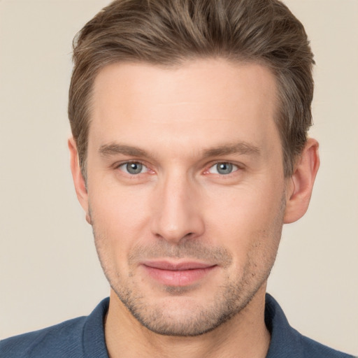 Joyful white young-adult male with short  brown hair and grey eyes