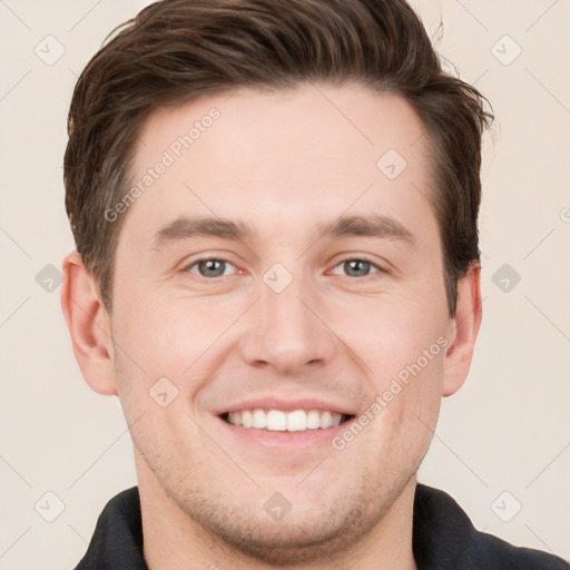 Joyful white young-adult male with short  brown hair and grey eyes