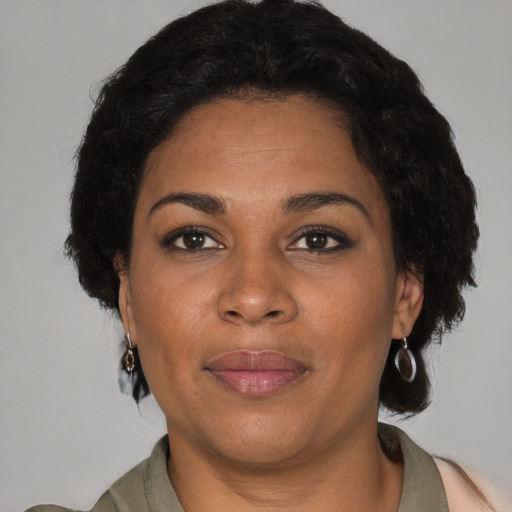 Joyful black adult female with short  brown hair and brown eyes
