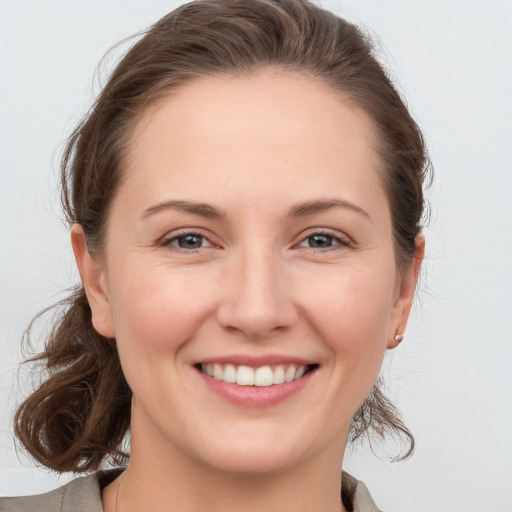 Joyful white young-adult female with medium  brown hair and grey eyes