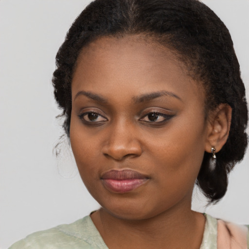 Joyful black young-adult female with long  black hair and brown eyes