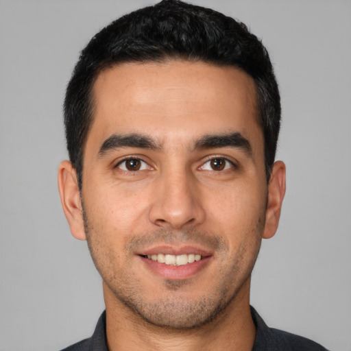 Joyful white young-adult male with short  black hair and brown eyes