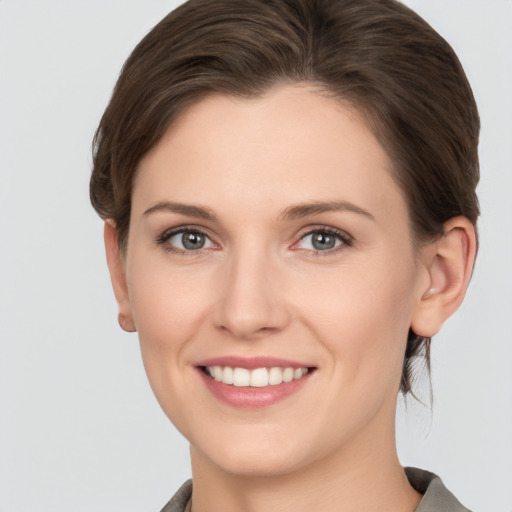 Joyful white young-adult female with medium  brown hair and grey eyes