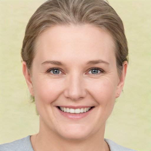 Joyful white young-adult female with short  brown hair and grey eyes