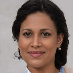 Joyful latino adult female with medium  brown hair and brown eyes