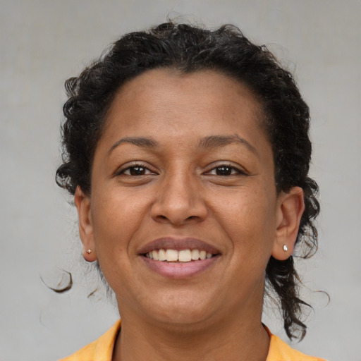 Joyful latino adult female with medium  brown hair and brown eyes