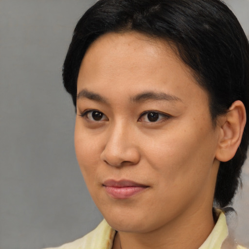 Joyful asian young-adult female with short  brown hair and brown eyes
