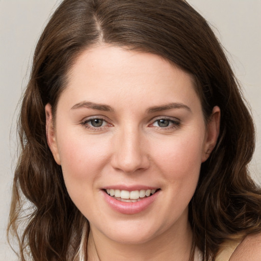 Joyful white young-adult female with long  brown hair and grey eyes