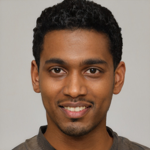 Joyful black young-adult male with short  black hair and brown eyes