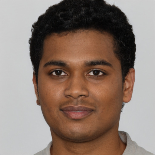 Joyful black young-adult male with short  black hair and brown eyes