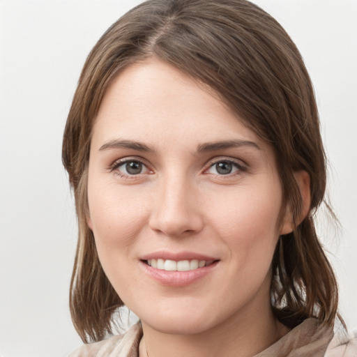 Joyful white young-adult female with medium  brown hair and grey eyes