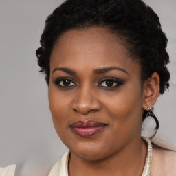 Joyful black young-adult female with long  brown hair and brown eyes