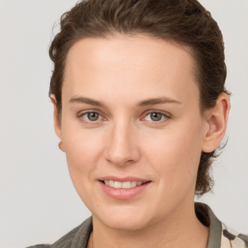 Joyful white young-adult female with short  brown hair and grey eyes