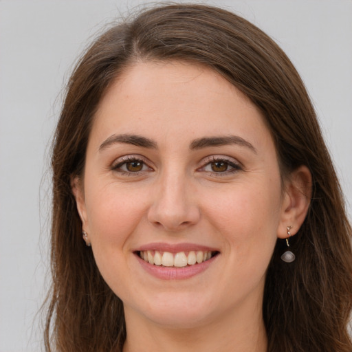 Joyful white young-adult female with long  brown hair and grey eyes