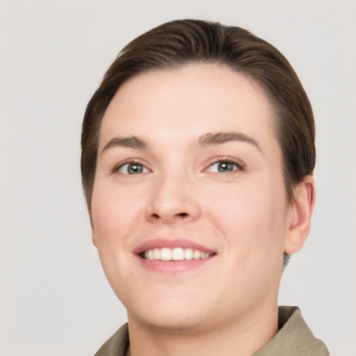 Joyful white young-adult female with short  brown hair and grey eyes