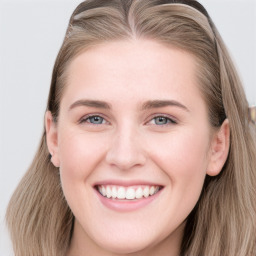 Joyful white young-adult female with long  brown hair and blue eyes