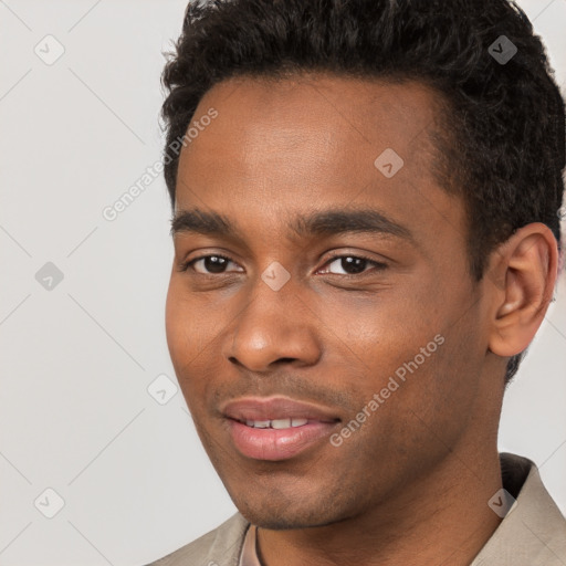 Joyful black young-adult male with short  brown hair and brown eyes