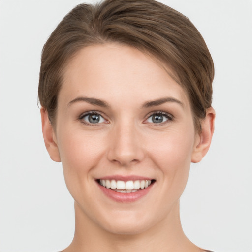 Joyful white young-adult female with short  brown hair and grey eyes