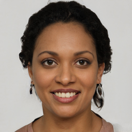 Joyful black young-adult female with short  black hair and brown eyes