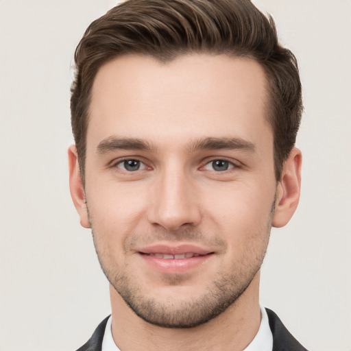 Joyful white young-adult male with short  brown hair and grey eyes