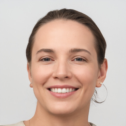 Joyful white young-adult female with medium  brown hair and grey eyes