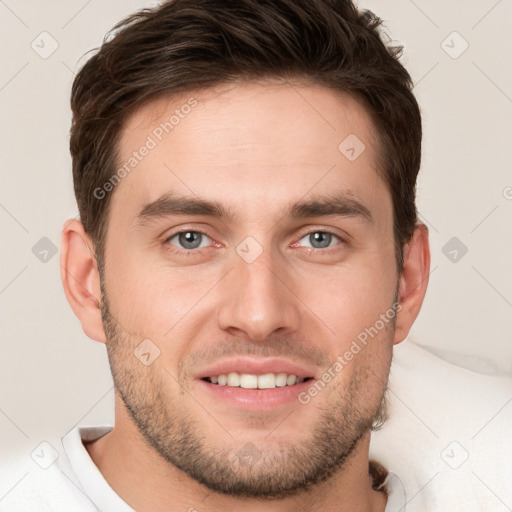 Joyful white young-adult male with short  brown hair and grey eyes