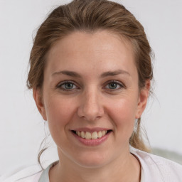 Joyful white young-adult female with medium  brown hair and grey eyes