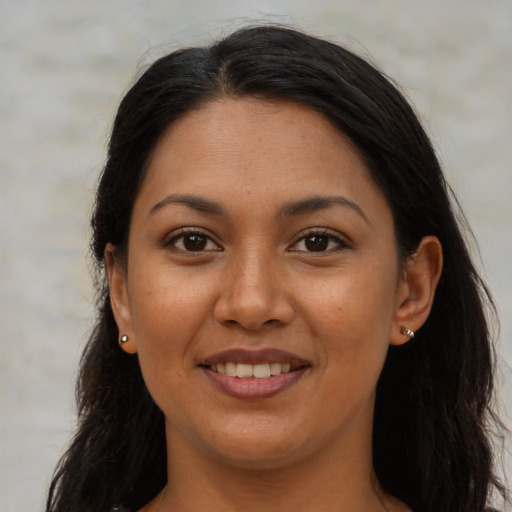 Joyful latino adult female with long  brown hair and brown eyes