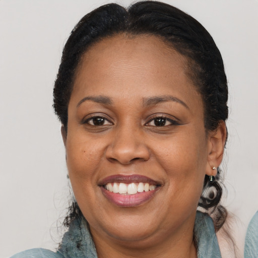 Joyful black adult female with medium  brown hair and brown eyes