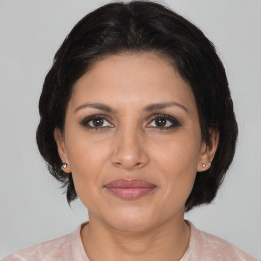 Joyful latino adult female with medium  brown hair and brown eyes