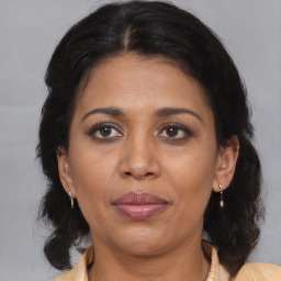 Joyful latino adult female with medium  brown hair and brown eyes
