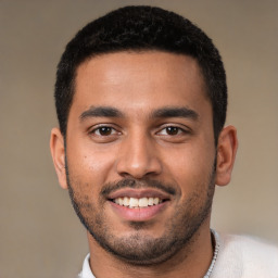 Joyful latino young-adult male with short  black hair and brown eyes