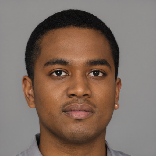 Joyful black young-adult male with short  brown hair and brown eyes