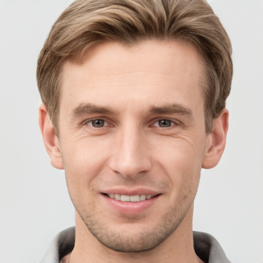 Joyful white young-adult male with short  brown hair and grey eyes