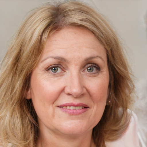 Joyful white adult female with medium  brown hair and blue eyes