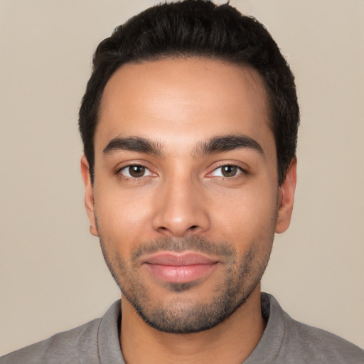 Joyful latino young-adult male with short  black hair and brown eyes