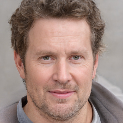 Joyful white adult male with short  brown hair and grey eyes