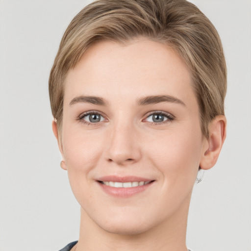 Joyful white young-adult female with short  brown hair and grey eyes